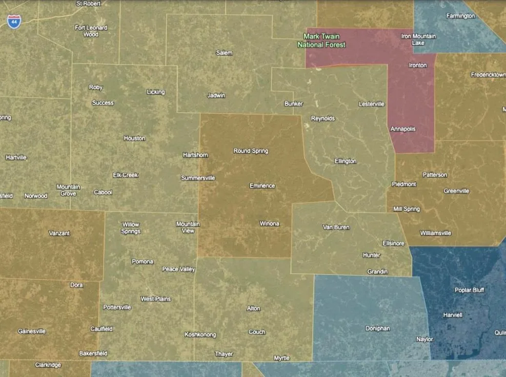 Shannon County, Missouri and its neighbours with Wildfire Hazard, Water Rights, Radon Zone 1 and Well Depth switched on: the bands of all four layers in tan, orange, red and blue across the county and its neighbours.
